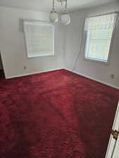 Empty room featuring carpet and baseboards