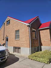 View of home's exterior with a metal roof and brick siding