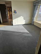 Empty room featuring dark colored carpet and baseboards