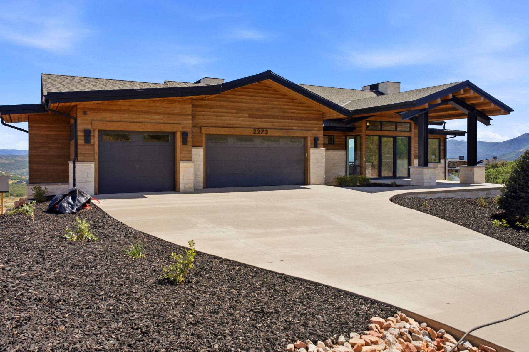 Contemporary single-story residence featuring natural wood siding and stone accents