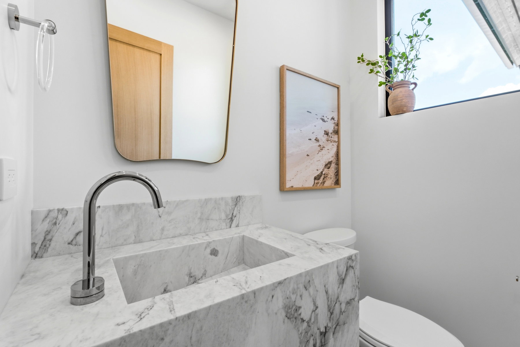 Integrated white marble vanity with a rectangular basin and a polished chrome faucet