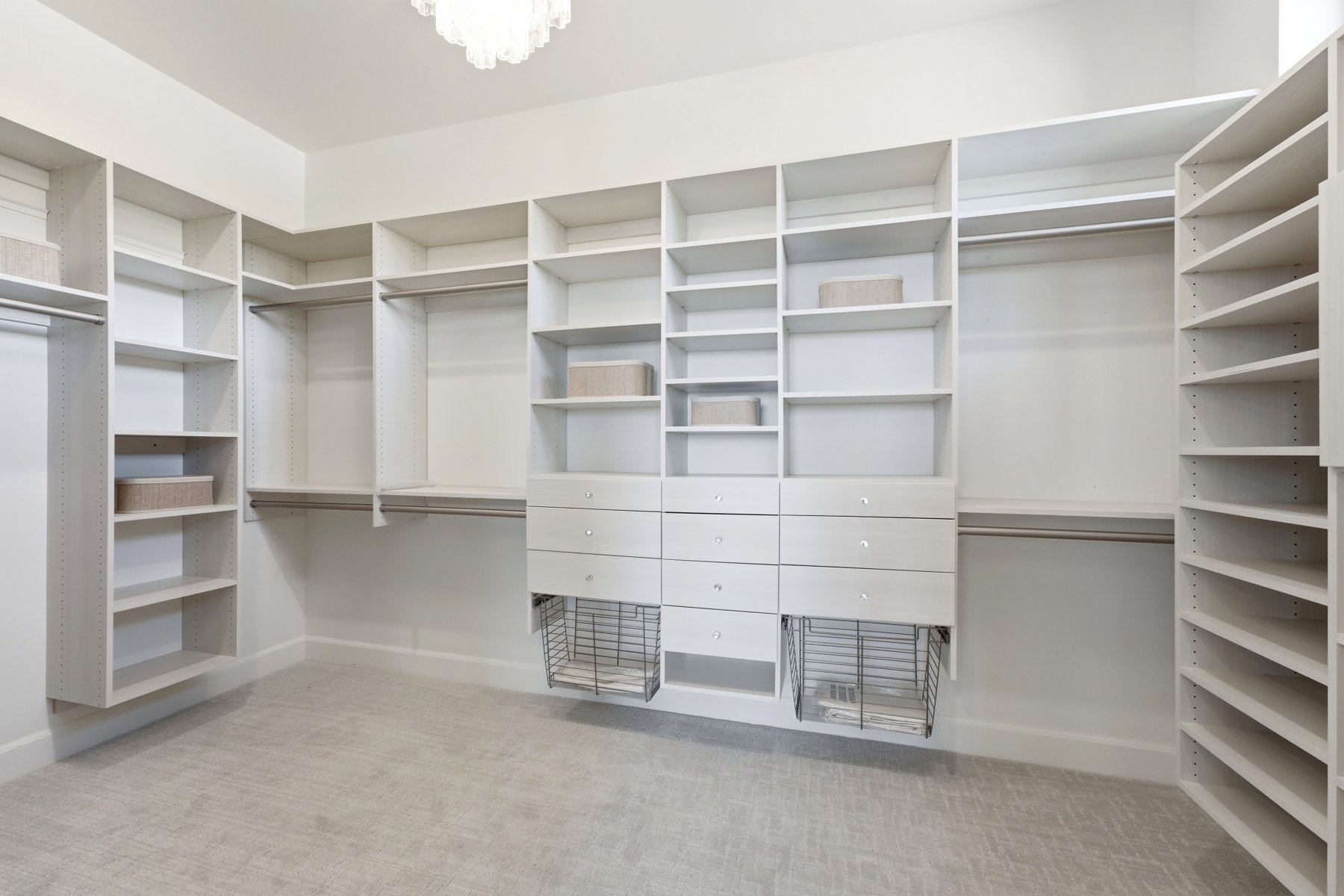 Custom closet system featuring extensive shelving, multiple hanging rods, built-in drawers, and integrated wire baskets