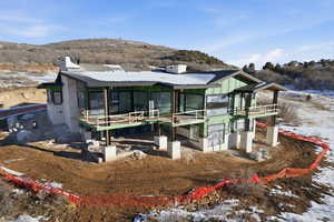 Snow covered house with a chimney and a sunroom