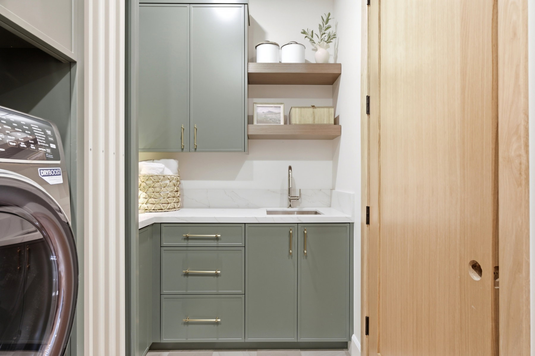 Corner utility sink with a brushed nickel faucet, set within a white countertop