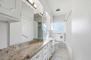 Full bathroom featuring vanity, light tile patterned floors, and washtub / shower combination
