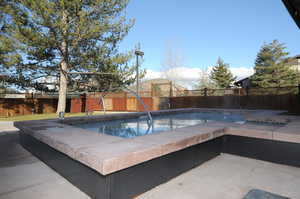 View of pool with a fenced backyard and a patio