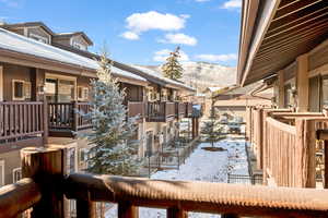 Snow covered property featuring a mountain view and a balcony