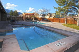 Community pool featuring a patio, a fenced backyard, and a residential view