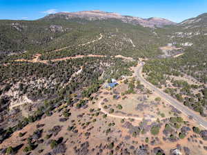 Aerial view of property and surrounding area featuring a mountainous background and rural landscape