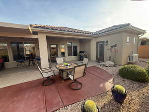 Back of house and casita entrance. Patio featuring outdoor dining space, covered and open patio areas, a tile roof, and stucco siding
