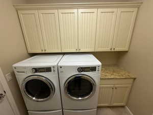 Washroom with cabinet space and washer and dryer