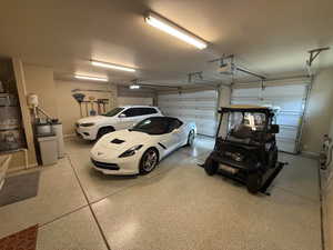 Garage featuring epoxy floors, secured water heater and a garage door opener