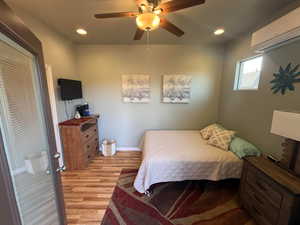Casita Bedroom with a Heat/AC mini-split, light wood-style flooring, ceiling fan, and recessed lighting