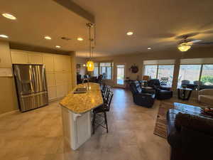 Kitchen with a kitchen breakfast bar, light granite  countertops, open floor plan, pendant lighting, and recessed lighting