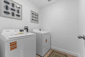 Laundry area with light wood-type flooring and washing machine and dryer