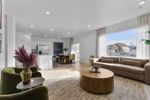 Living area featuring light wood finished floors and recessed lighting