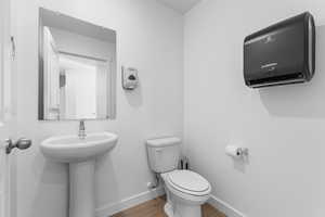 Half bath featuring toilet and wood finished floors