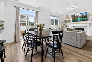 Dining room with a tiled fireplace and light wood finished floors