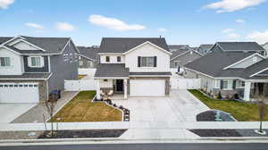 View of front of house with a gate, a residential view, concrete driveway, and stone siding