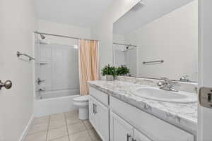 Full bathroom featuring vanity, shower / tub combo with curtain, and light tile patterned floors