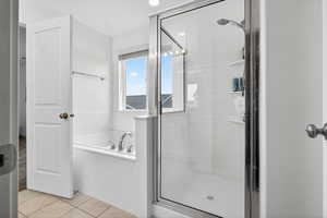 Full bathroom with a bath, a shower stall, and light tile patterned flooring