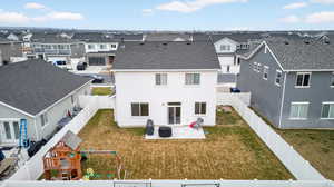 Rear view of property with a patio area, a fenced backyard, a residential view, a playground, and roof with shingles