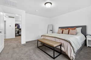 Bedroom featuring light colored carpet