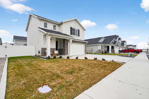View of front of home featuring a porch, concrete driveway, a garage, stone siding, and a residential view