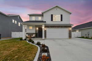 View of front of property with a gate, stone siding, a porch, driveway, and an attached garage