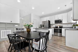 Dining space with light wood finished floors and recessed lighting