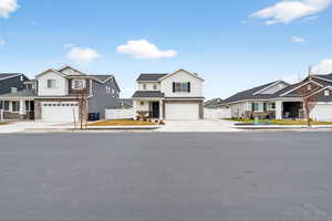 View of front facade featuring a gate, a residential view, concrete driveway, an attached garage, and stone siding