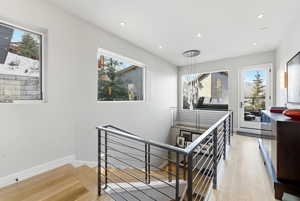 Staircase with wood-type flooring and recessed lighting