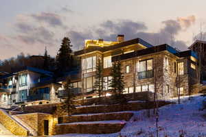 View of front of property featuring stone siding and a chimney