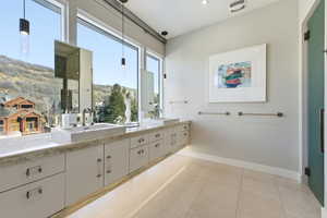 Bathroom featuring double vanity and light tile patterned floors