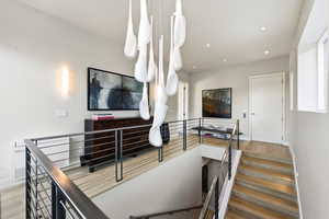 Stairway with wood finished floors and recessed lighting