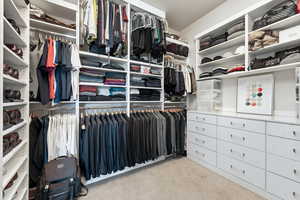 Walk in closet with light carpet