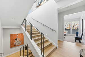 Stairs with wood finished floors and baseboards