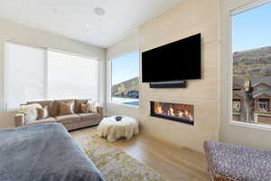 Bedroom featuring a large fireplace, wood-type flooring, and multiple windows