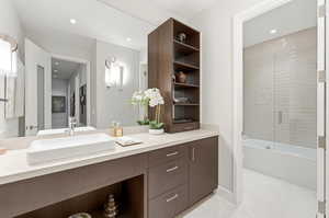 Full bath featuring vanity and combined bath / shower with glass door