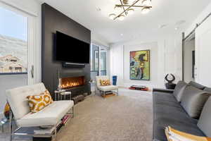 Carpeted living area with a barn door and a fireplace