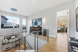 Office with light wood-type flooring and recessed lighting
