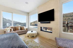 Bedroom featuring a high end fireplace, hardwood / wood-style floors, and multiple windows