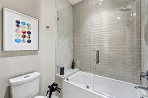 Full bath with bath / shower combo with glass door and toilet