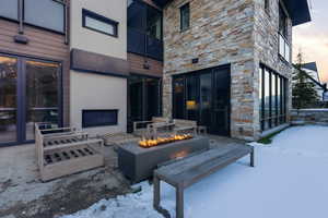 Snow covered patio with a fire pit and a patio area