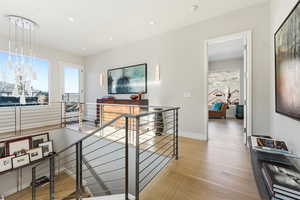 Hallway featuring an upstairs landing and light wood-style floors