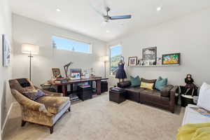 Living room featuring carpet flooring and a ceiling fan