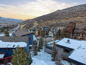 Snowy aerial view featuring a mountain view and a residential view