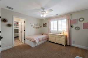 Bedroom with carpet flooring, ceiling fan, and ensuite bathroom