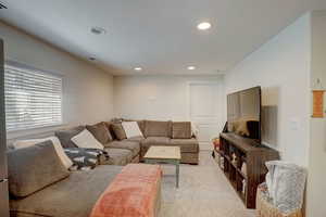 Living room with recessed lighting and light colored carpet