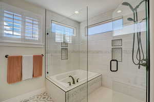 Bathroom featuring a garden tub, a shower stall, and recessed lighting